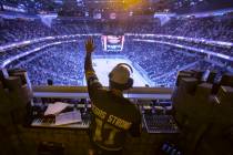 Golden Knights music director Jake Wagner waves to the crowd at the end of the first period dur ...