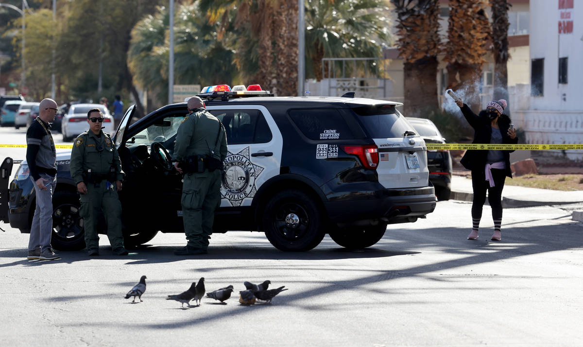 A woman burns sage as Las Vegas police investigate at the scene of a shooting on East Sahara Av ...