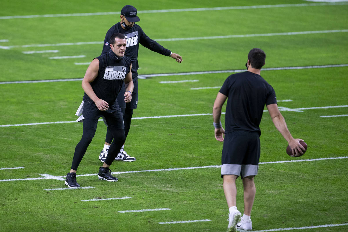 Raiders quarterbacka Derek Carr, left, Marcus Mariota, right, and Nathan Peterman (3) warm up b ...