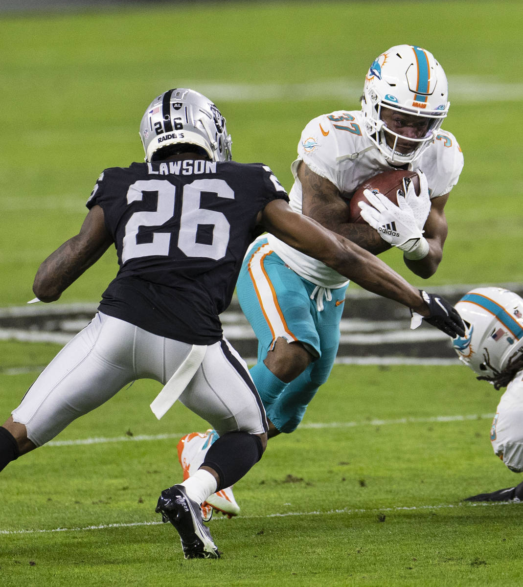 Raiders cornerback Nevin Lawson (26) defends Miami Dolphins running back Myles Gaskin (37) duri ...