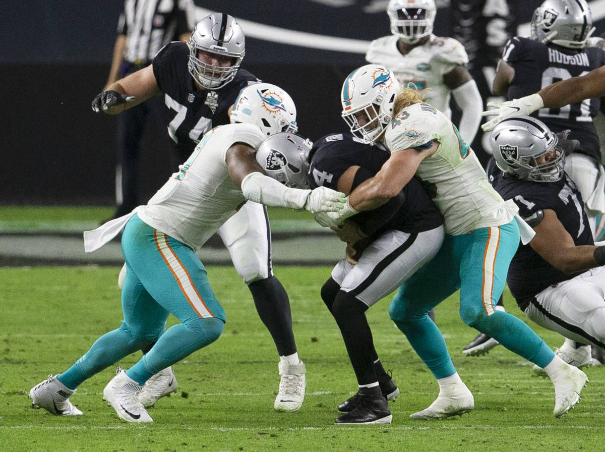 Raiders quarterback Derek Carr (4) is sacked by Miami Dolphins outside linebacker Andrew Van Gi ...