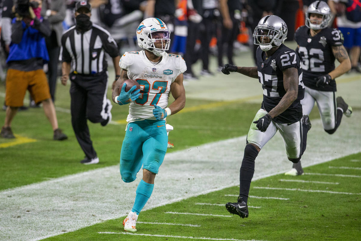 Miami Dolphins running back Myles Gaskin (37) runs past Raiders cornerback Trayvon Mullen (27) ...