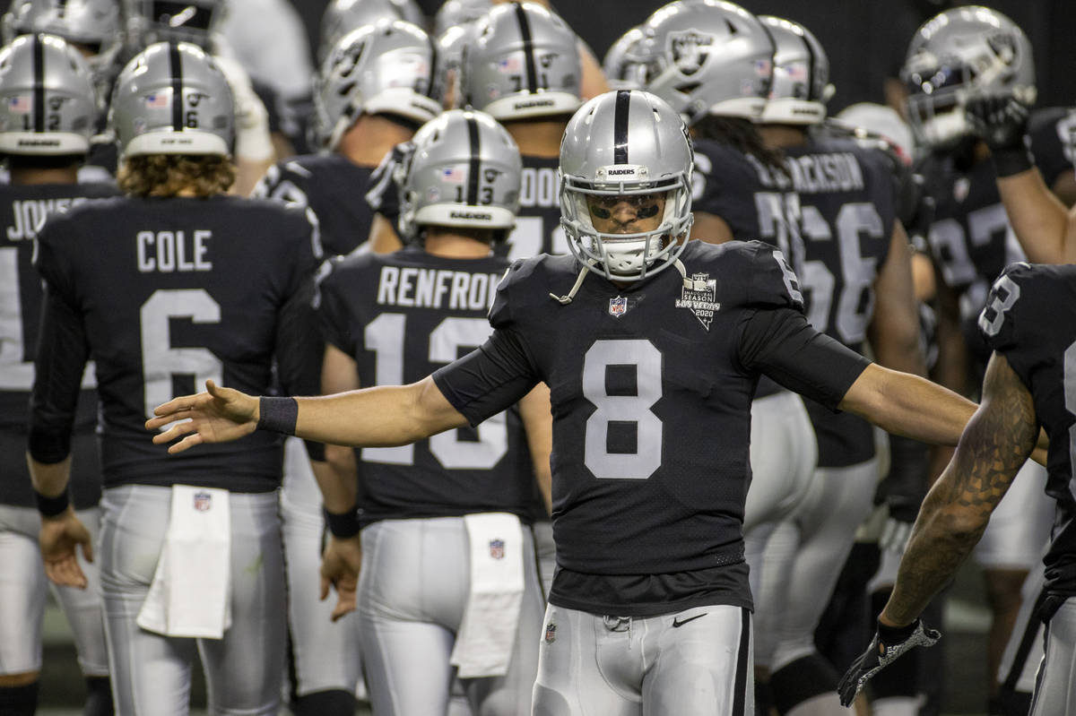 Raiders quarterback Marcus Mariota (8) greets his teammates during warm ups before an NFL footb ...