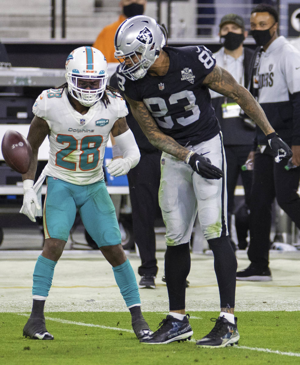 Raiders tight end Darren Waller (83) spikes the ball in the face of Miami Dolphins strong safet ...