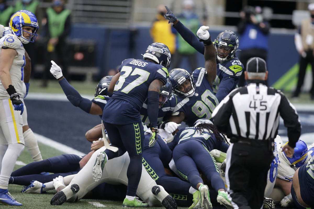 Seattle Seahawks players, including defensive tackle Jarran Reed (90) react after the Seahawks ...