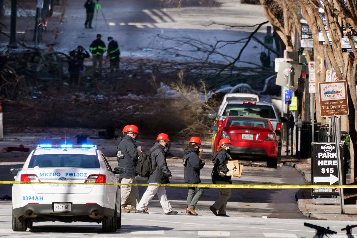 Investigators walk near the scene of an explosion Saturday, Dec. 26, 2020, in Nashville, Tenn. ...