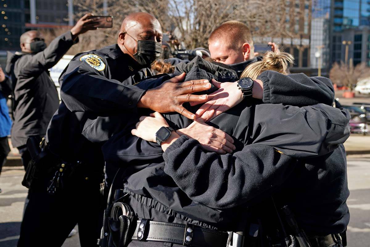 Nashville Police Chief John Drake, left, joins a group of police officers as they embrace after ...
