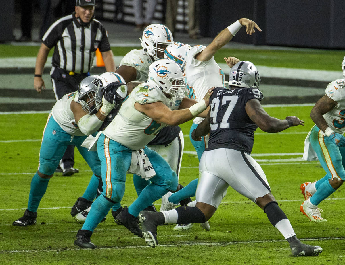 Miami Dolphins quarterback Ryan Fitzpatrick (14) gets his facemark pulled by Raiders defensive ...