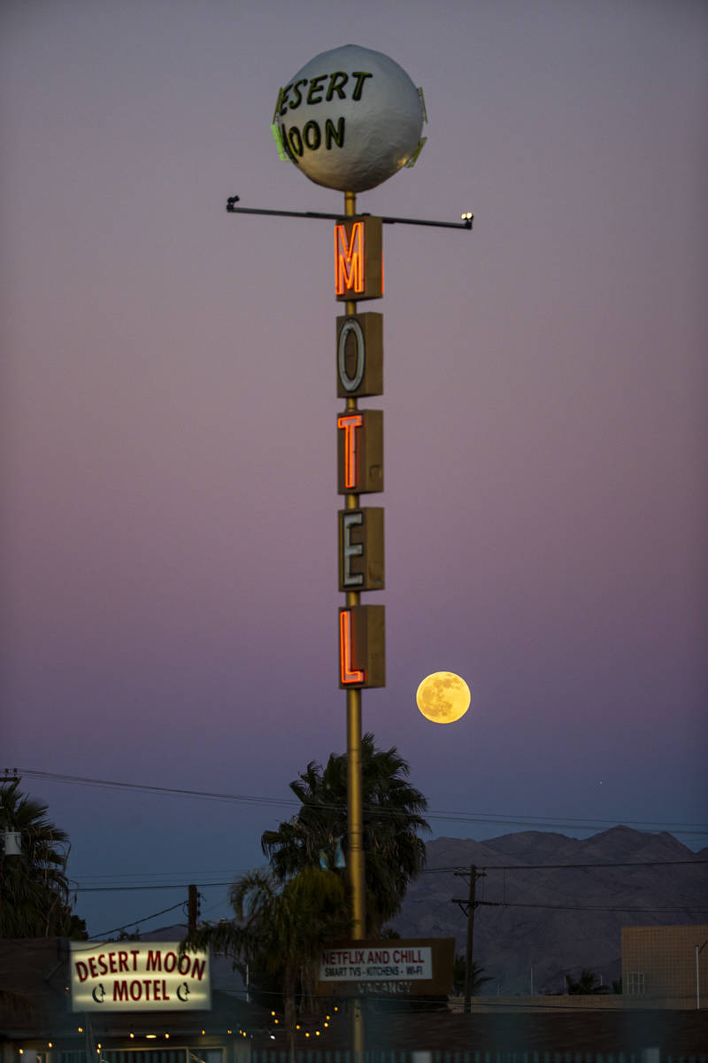 The last full moon of the year rises above the Desert Moon Motel sign on east Fremont Street in ...