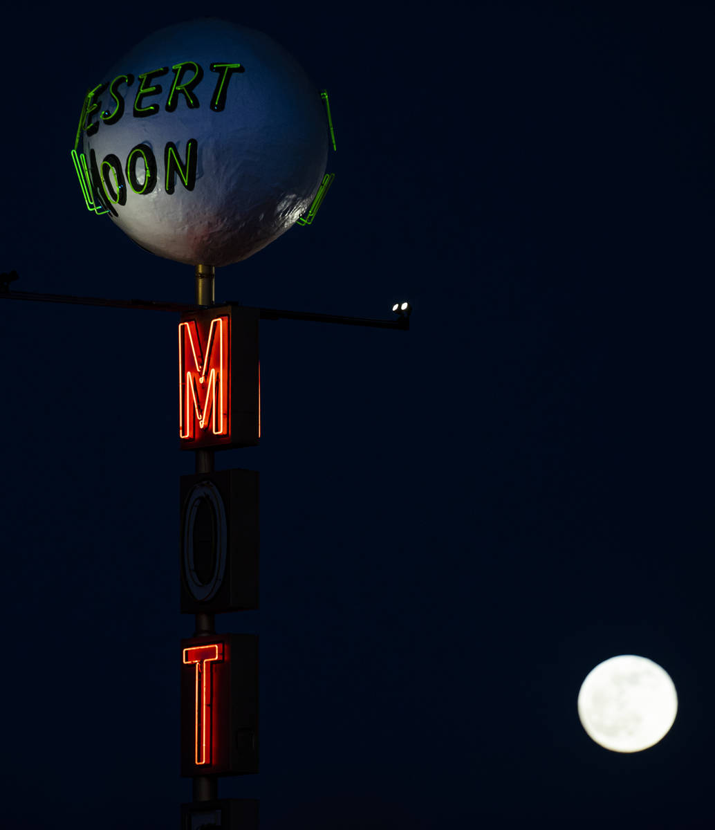 The last full moon of the year rises above the Desert Moon Motel sign on east Fremont Street in ...