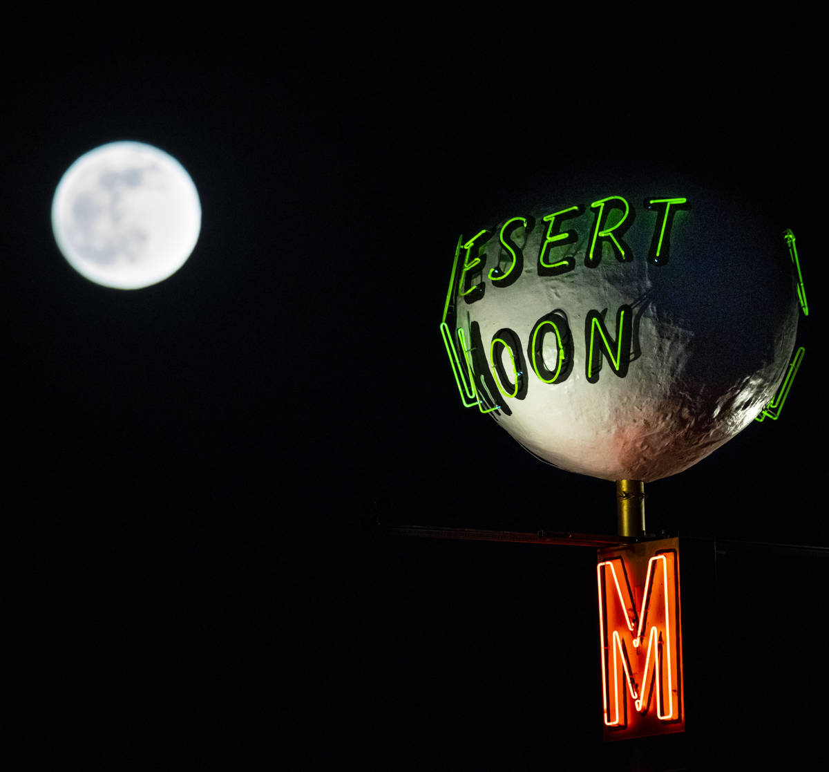 The last full moon of the year rises above the Desert Moon Motel sign on east Fremont Street in ...