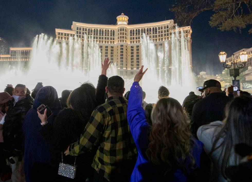 Individuals watch the Bellagio Fountains while celebrating New Years Eve on the Las Vegas Strip ...