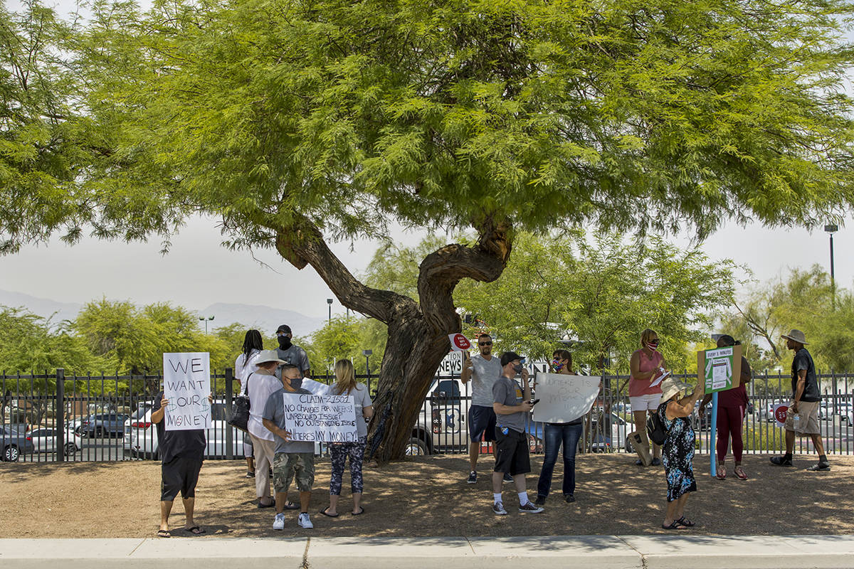 Gig workers gather with signs along E. Washington Ave. to protest the Nevada unemployment offic ...