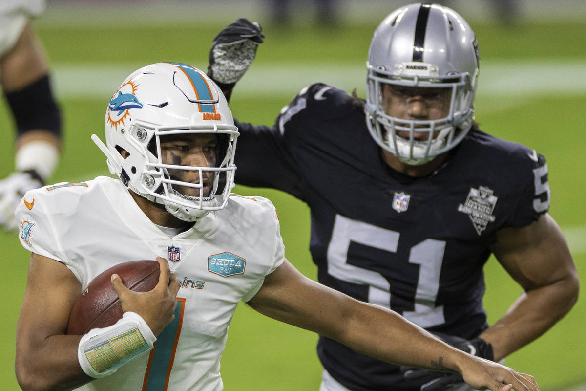 Miami Dolphins quarterback Tua Tagovailoa (1) scrambles past Raiders defensive end Vic Beasley ...
