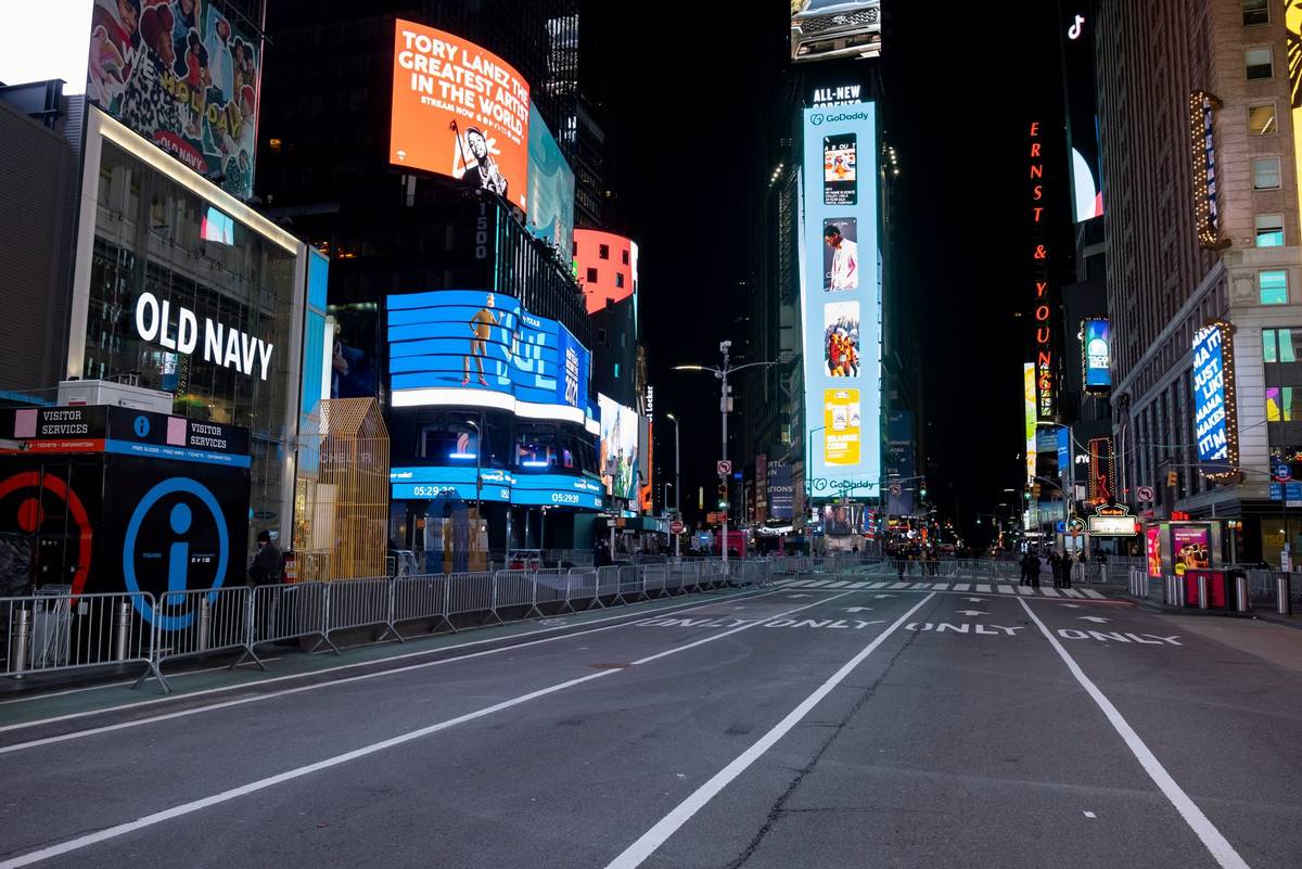 Seventh Avenue is mostly empty during what would normally be a Times Square packed with people, ...