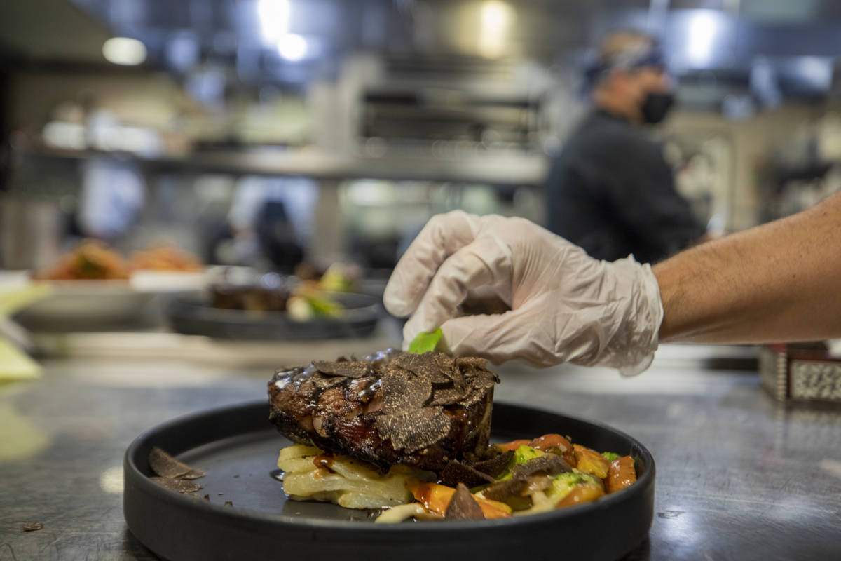 Chef Stephen Blandino puts a final touch on a course at Americana on Thursday, Dec. 31, 2020, i ...