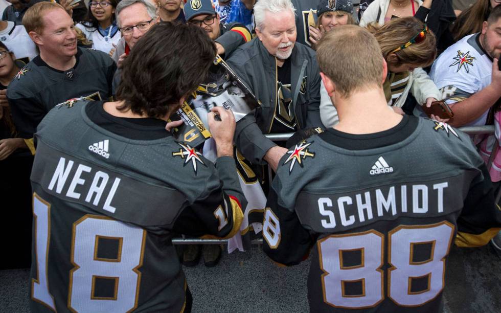 Vegas Golden Knights left wing James Neal (18) and defenseman Nate Schmidt (88) sign autographs ...