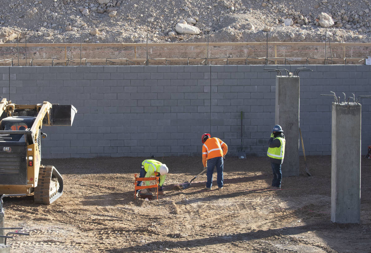 Construction workers at an underground parking garage at the Evora apartment complex site where ...