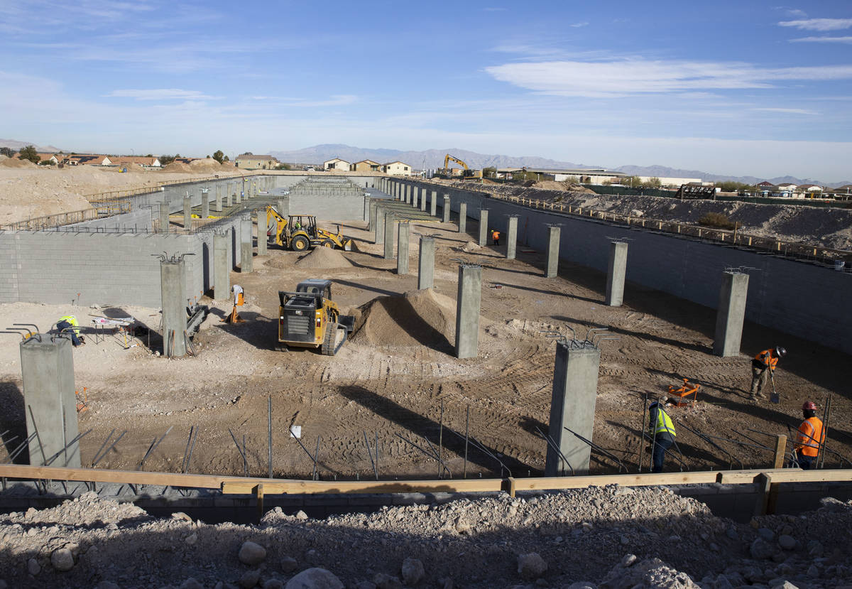 Construction workers at an underground parking garage at the Evora apartment complex site where ...