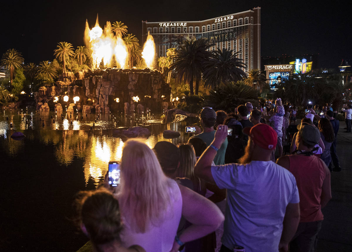 People on the Strip watch the first volcano show since the opening of the The Mirage earlier in ...