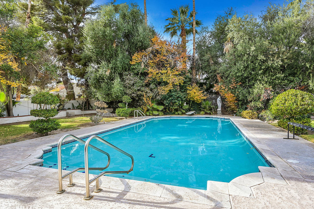 The backyard has a lap-style pool has mature landscaping, lush vegetation, grass, rose gardens, ...