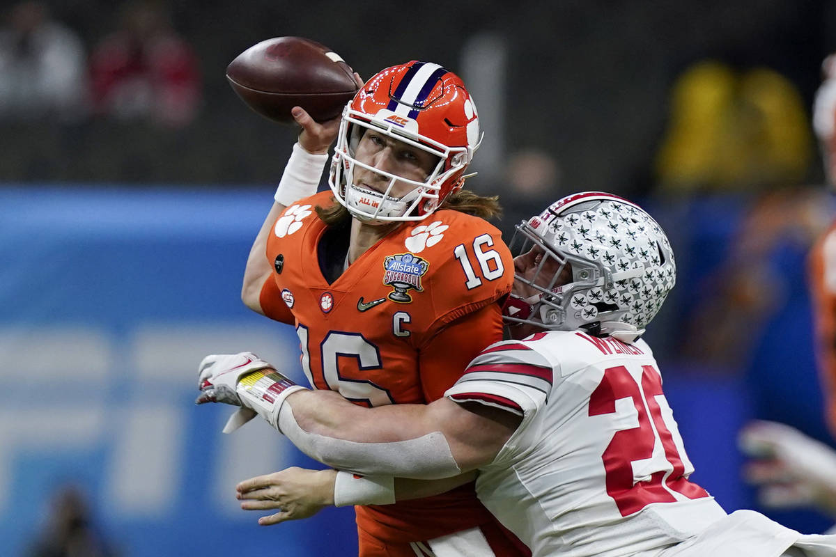 Clemson quarterback Trevor Lawrence passes under pressure by Ohio State linebacker Pete Werner ...