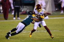 Washington Football Team's Cam Sims (89) is tackled by Philadelphia Eagles' T.J. Edwards (57) d ...