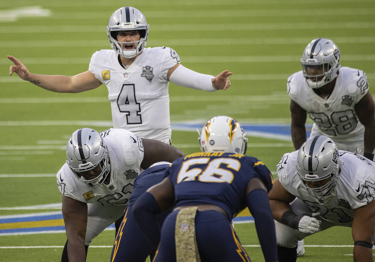 Las Vegas Raiders quarterback Derek Carr (4) calls an audible over Los Angeles Chargers linebac ...
