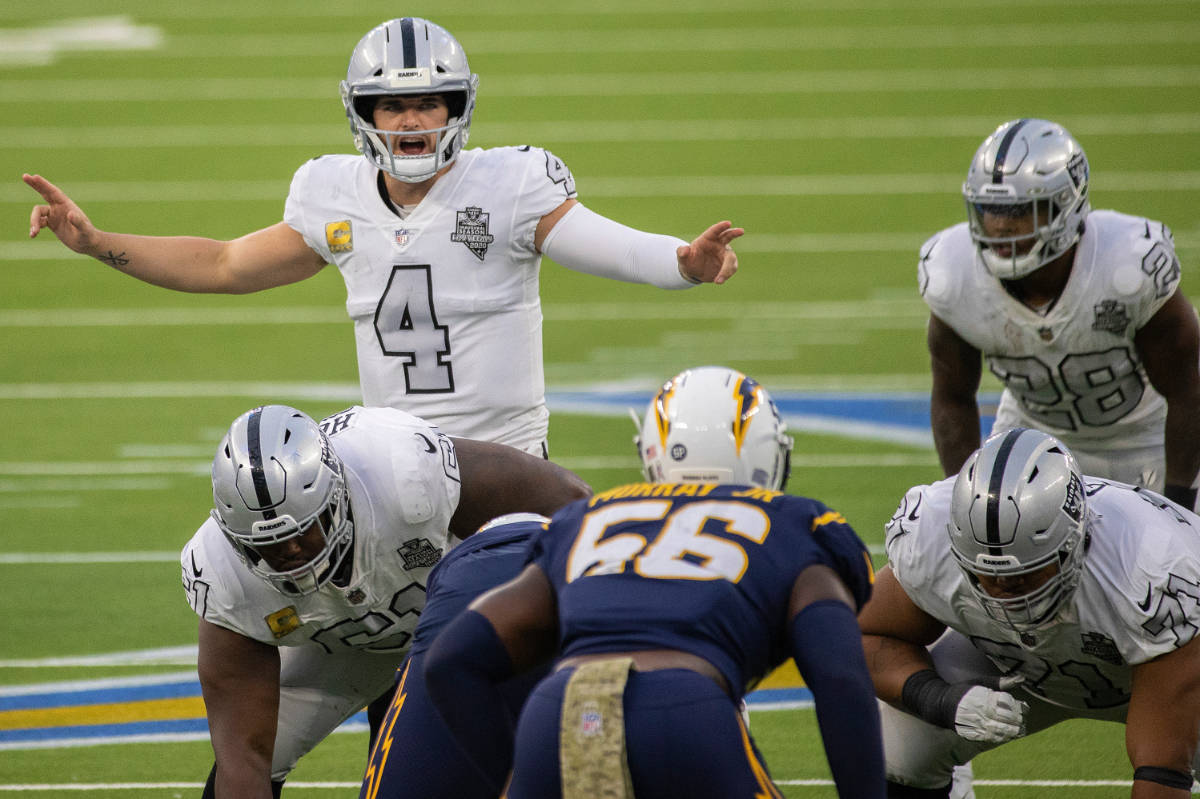 Las Vegas Raiders quarterback Derek Carr (4) calls an audible over Los Angeles Chargers linebac ...
