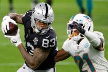 Las Vegas Raiders tight end Darren Waller (83) makes a catch over Miami Dolphins free safety Er ...