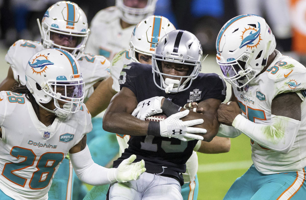 Raiders wide receiver Nelson Agholor (15) is stacked up by Miami Dolphins strong safety Bobby M ...