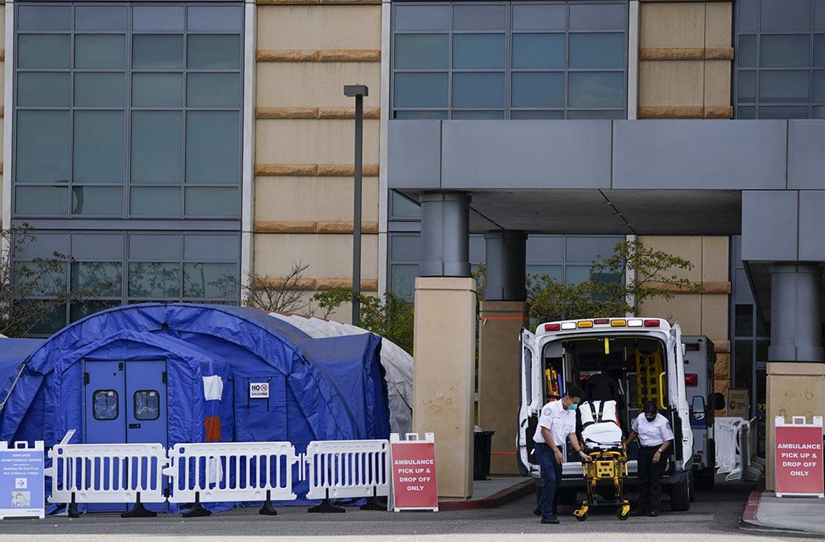 In a Dec. 17, 2020, file photo, medical workers remove a stretcher from an ambulance near medic ...