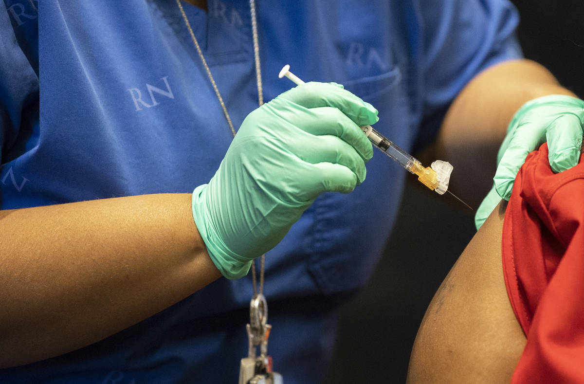 Tymeeka Davis, right, is given the COVID-19 vaccine at the North Las Vegas VA Medical Center on ...