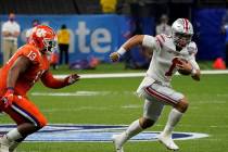 Ohio State quarterback Justin Fields runs past Clemson defensive tackle Tyler Davis during the ...