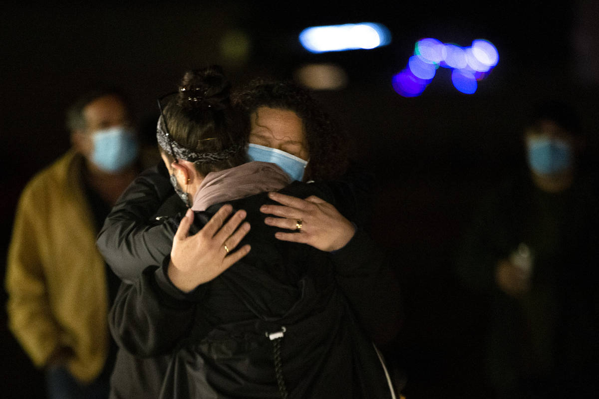 Annmarie Echevarria hugs her friend Krisztina Bessenyei at a vigil for her husband Eric Echevar ...