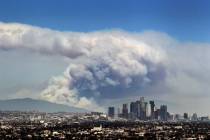 Smoke from wildfires burning in Angeles National Forest fills the sky behind the Los Angeles sk ...