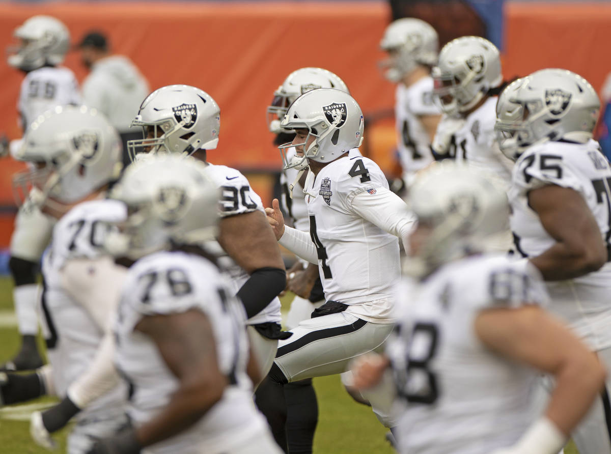 The Raiders warm up before the start of an NFL football game against the Denver Broncos on Sund ...