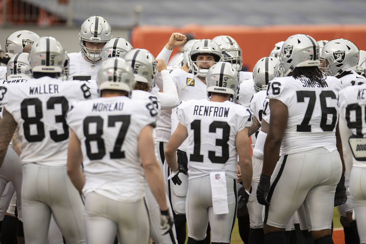 Raiders quarterback Derek Carr, middle, fires up his team during warm ups before the start of a ...
