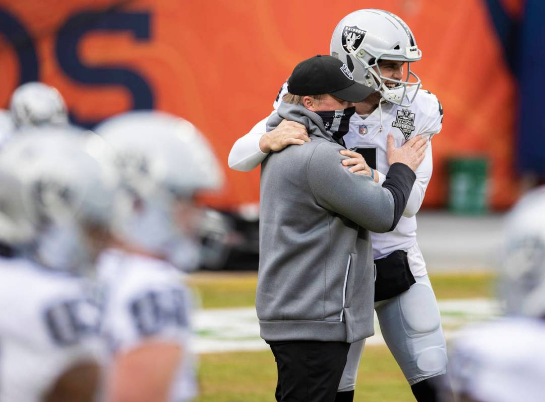 Raiders head coach Jon Gruden, left, hugs Raiders quarterback Derek Carr (4) during warm ups be ...