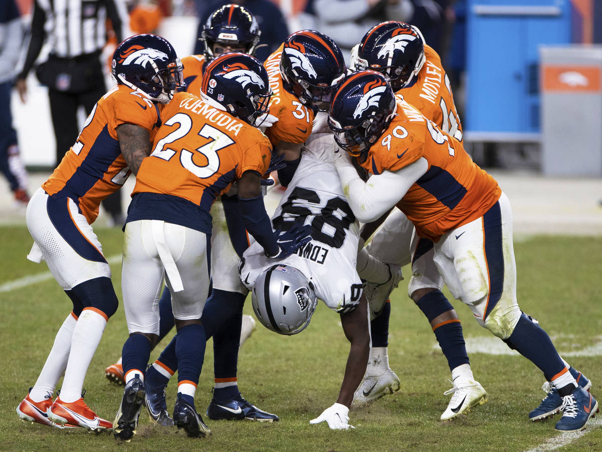 Raiders wide receiver Bryan Edwards (89) is gang tackled by Denver Broncos defenders in the fou ...