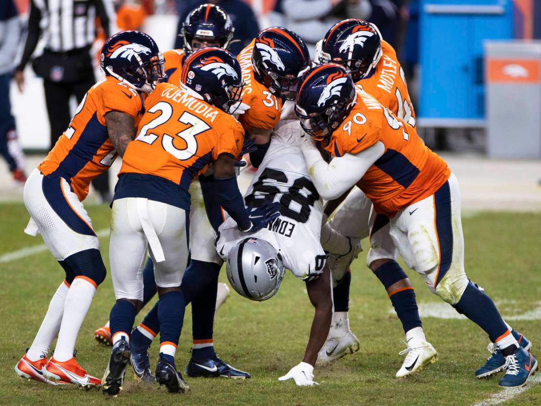 Raiders wide receiver Bryan Edwards (89) is gang tackled by Denver Broncos defenders in the fou ...