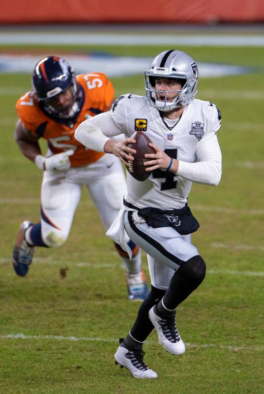 Raiders quarterback Derek Carr (4) scrambles past Denver Broncos defensive end DeMarcus Walker ...