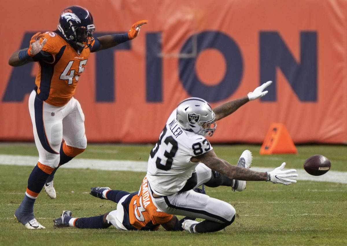 Raiders tight end Darren Waller (83) fumbles after being hit by Denver Broncos cornerback Micha ...