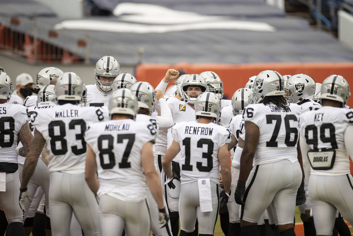 Raiders quarterback Derek Carr, middle, fires up his team during warm ups before the start of a ...