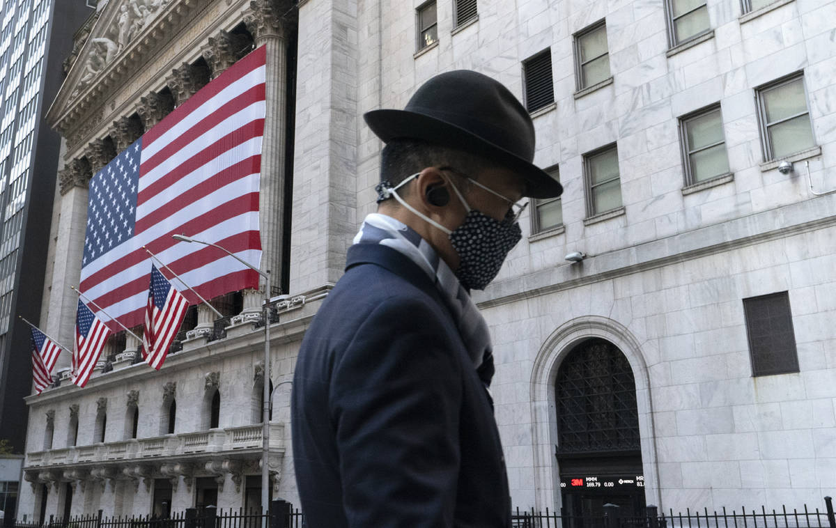 In a Nov. 16, 2020, file photo, a man wearing a mask passes the New York Stock Exchange, in New ...