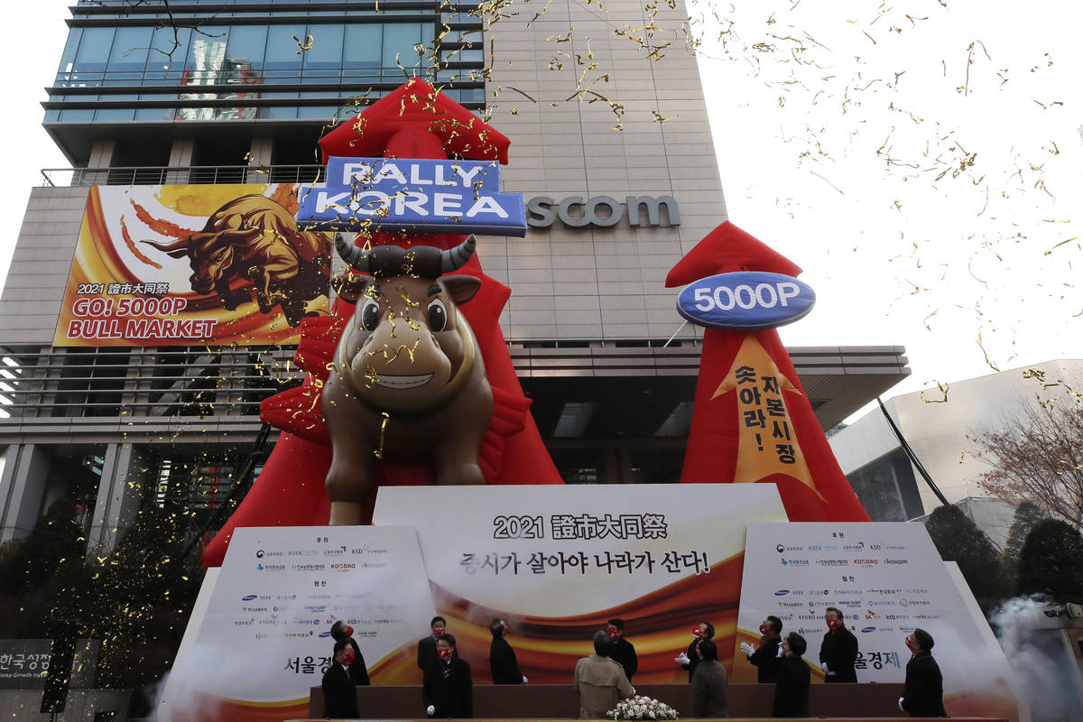 South Korean financial officers wearing face masks celebrate the opening for the Year 2021 trad ...
