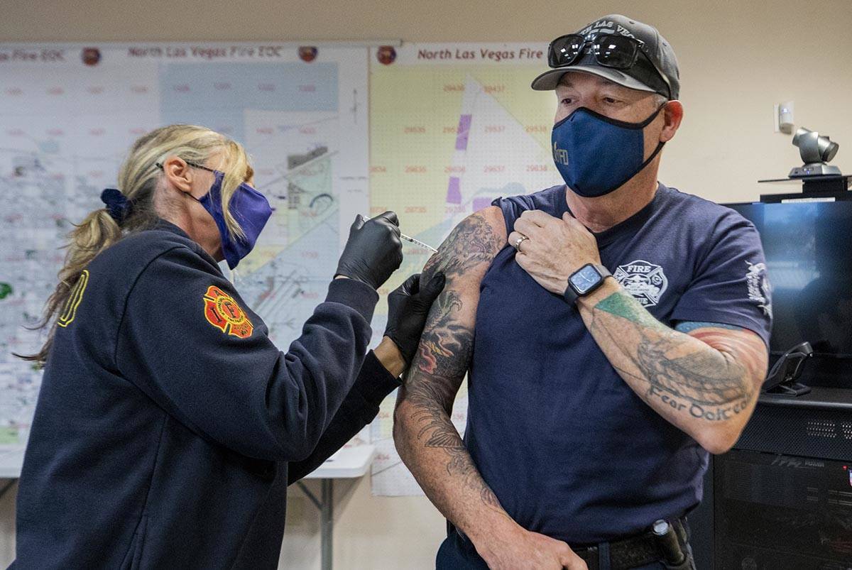 Emergency medical services chief Lisa Price, left, administers a COVID-19 vaccine to North Las ...