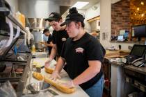 Haley Austin, right, and Nathan Cameron make sandwiches for customers while working at Capriott ...