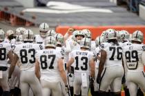 Raiders quarterback Derek Carr, middle, fires up his team during warm ups before the start of a ...