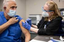 Registered Nurse Cass Petrykowski, left, receives the second dose of the Pfizer COVID-19 vaccin ...